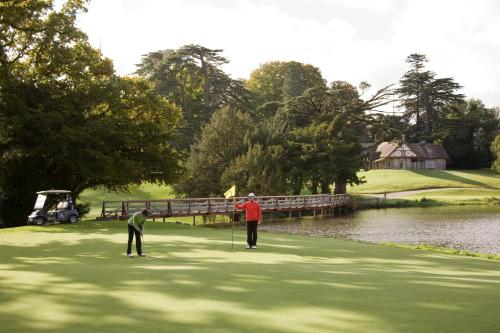 two men playing a game of golf near a pond at Silken Thomas Accommodation in Kildare