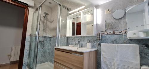 a bathroom with a sink and a shower at CASA CAXOTA: Planta baja con terraza y vistas al mar in Fisterra