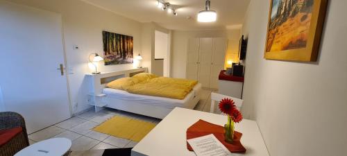 a bedroom with a bed and a table with a vase on it at Ferienwohnung "Tecklenburger Augenblicke" in Tecklenburg