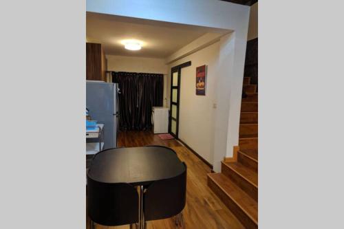 a living room with a black stool and stairs at Cozy designer loft near KL city center in Ampang