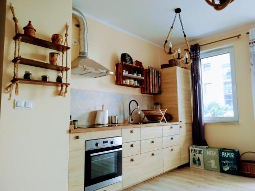a kitchen with wooden cabinets and a stove at ZATOKA ZEN PUCK in Puck