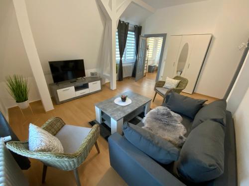 een woonkamer met een blauwe bank en een tafel bij Villa Nevada - Adults only in Bad Schandau