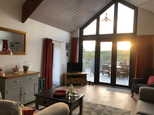 a living room with a large window and a tv at Red Kite Cottage in Carmarthen