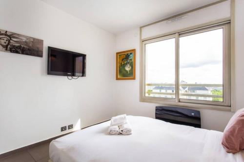 a bedroom with a bed and a tv and a window at prox.Gare Montparnasse-galeries lafayette! 4pers. in Paris