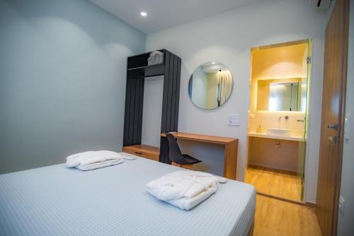 a bedroom with a bed with a sink and a mirror at Blue Velvet Coast Luxury Villas in Kokkíni Khánion