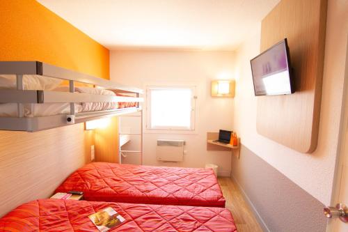 a small room with two beds and a tv at Premiere Classe Angers Est - St Barthelemy D'Anjou in Saint-Barthélemy-dʼAnjou