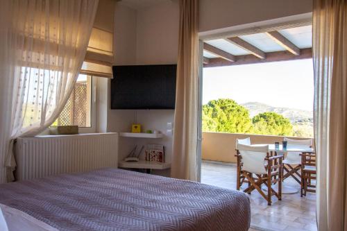 a bedroom with a bed and a table with chairs at Lida Garden Loft in Anavissos