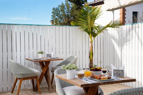 a patio with a table and chairs and a palm tree at Antonio's House in Sitges