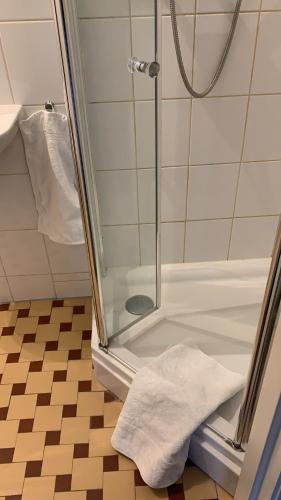 uma casa de banho com um chuveiro e uma toalha branca no chão em Studio-apartment in city-center em Amsterdã