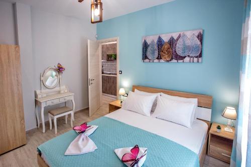 um quarto com uma cama grande e uma parede azul em Happy mini suites em Nea Peramos