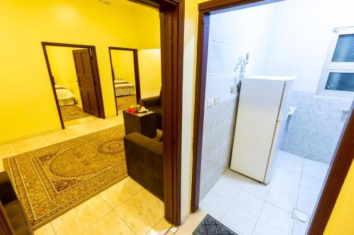 een badkamer met een koelkast en een kamer met een gang bij العييري للوحدات السكنية المفروشة الباحة 4 in Al Baha