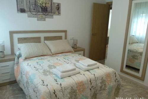 a bedroom with a bed with three towels on it at apartamentos Sonia YEIK in Muxia
