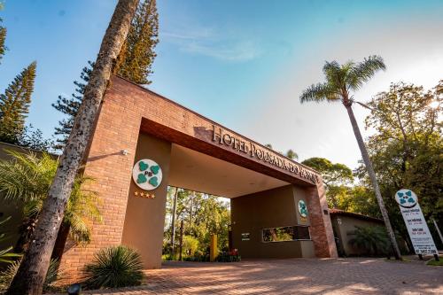 a brick building with a palm tree in front of it at Hotel Pousada do Bosque in Ponta Porã