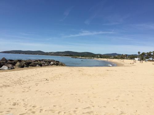 une plage de sable avec des personnes nageant dans l'eau dans l'établissement Mistral Gagnant, à Fréjus