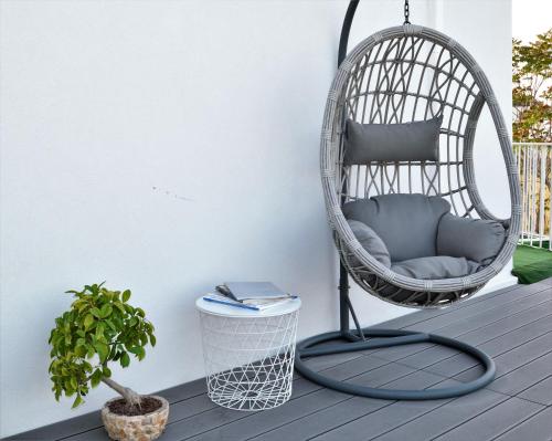 a hanging chair on a porch with a plant at Arneo Terra del Sole in Torre Lapillo