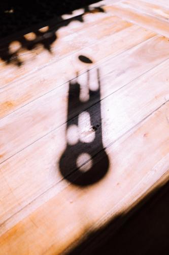 a shadow of a light on a wooden table at Adara Homestay in Banyuwangi