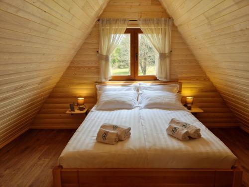 a bedroom with a bed with two pillows and a window at Hedonist Village in Žabljak