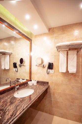 a bathroom with a sink and a shower at Lamar Azur Hotel in Dumyāţ al Jadīdah