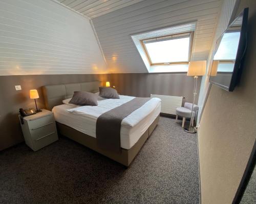 um quarto com uma cama grande e uma janela em Hôtel la Suite em Payerne