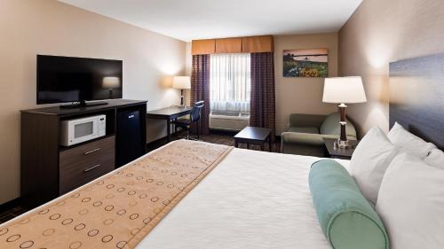 Habitación de hotel con cama y TV en Best Western Airport Inn, en Moline