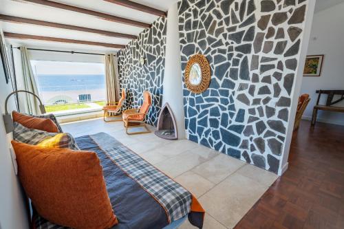 a living room with a stone wall and a couch at Casa Maravilha III in Caniço
