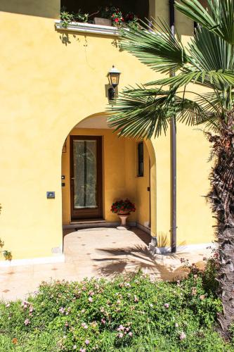 an entry to a building with a door and a palm tree at Villa Elena appartamento in villa in Montinelle