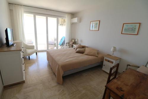 une chambre avec un lit, un bureau et une fenêtre dans l'établissement Amazing sea view 2 bedroom beach front 303, à Cannes