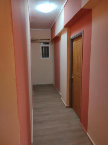 a hallway with orange walls and a door at Hotel Lido in Athens