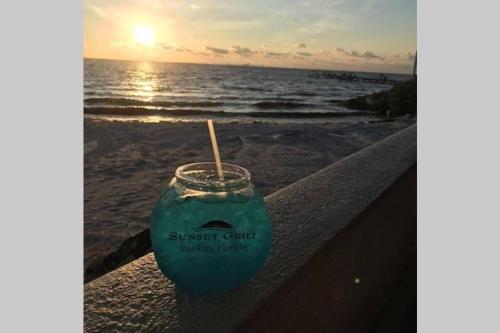 a drink sitting on a railing at the beach at Little Harbor Resort #306 Tampa Bay FL Beach, Bayside, 2 Pools in Ruskin