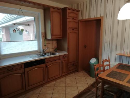 a kitchen with a sink and a window and a table at Meyers Ferienwohnung in Elmlohe
