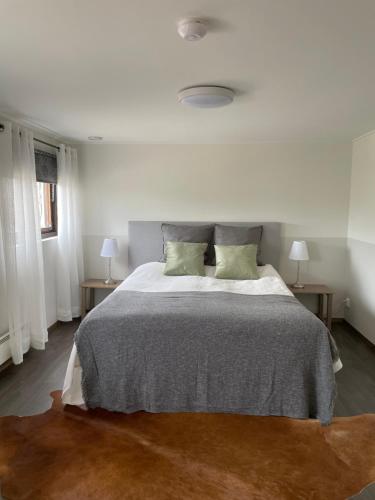 a white bedroom with a large bed with two tables at Hults-Boaryd Golf och B&B in Hult
