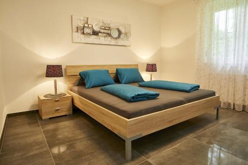 a bedroom with a large bed with blue pillows at Seeblick Susanne in Schiefling am See