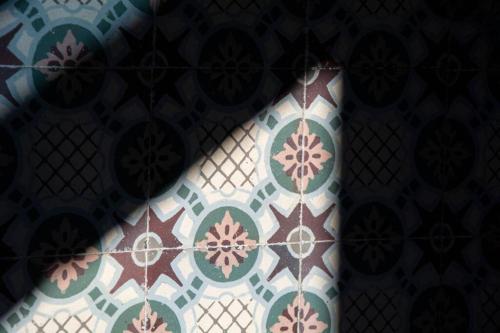 a close up of a tile wall with a pattern on it at La Gavroche - Gîte in Montreuil-sur-Mer