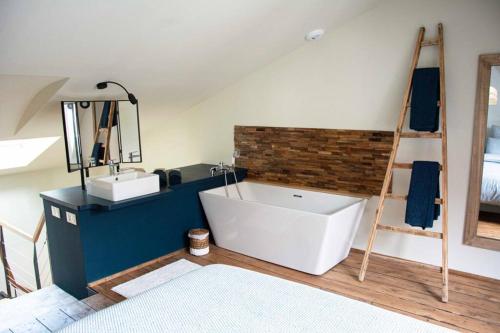 a bathroom with a white tub and a ladder at La Gavroche - Gîte in Montreuil-sur-Mer