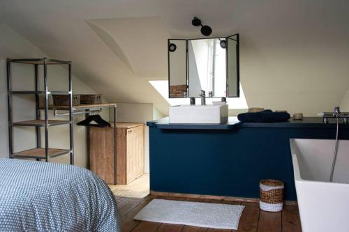 a bedroom with a sink and a mirror on a counter at La Gavroche - Gîte in Montreuil-sur-Mer