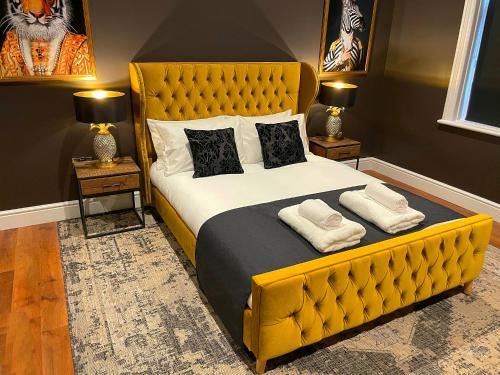 a bedroom with a large yellow bed with two lamps at Apartment 'Boho' in Yeovil