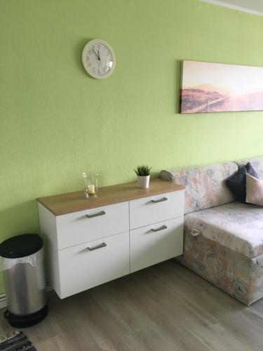sala de estar con sofá y reloj en la pared en Laboe-Hafen, en Laboe