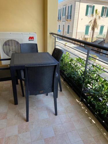 a black table and chairs on a balcony with a truck at Ada's House in Alghero