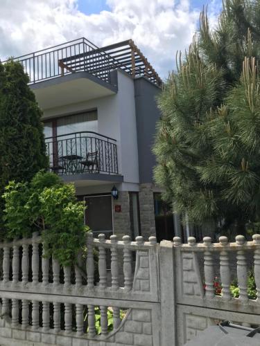 a house with a white fence and trees at Family Hotel Astra in Chernomorets