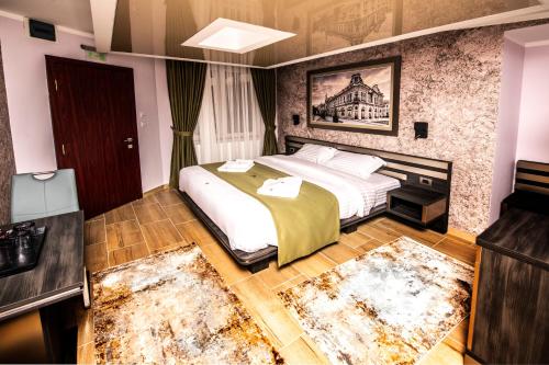 a bedroom with a bed and two rugs at Hotel Novotheos in Oradea
