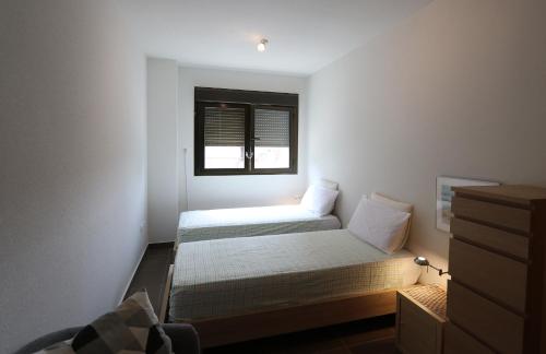 een kleine slaapkamer met 2 bedden en een raam bij Aguilas Residencial El Cedro BID2 in Águilas