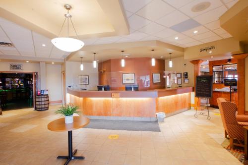 a lobby of a restaurant with a counter and tables at Neighbourhood Inn Hotels in Bonnyville in Bonnyville