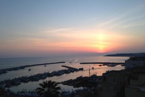 a sunset over a body of water with a beach at Il mare in un bicchiere in Sciacca