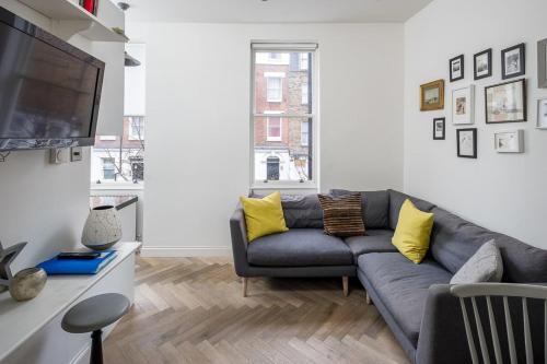a living room with a couch and a flat screen tv at Amazing Cosy Central London Apartment 3 mins to Marylebone in London