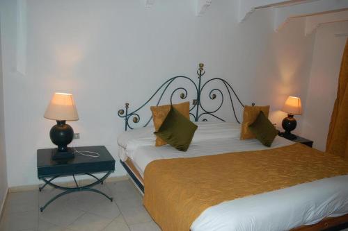 two beds in a room with two lamps on tables at Djerba Aqua Resort in Midoun