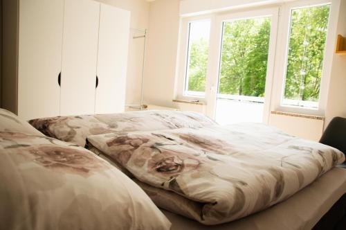 twee bedden in een kamer met twee ramen bij Naturnahe schöne neu gestaltete Ferienwohnung in Würselen