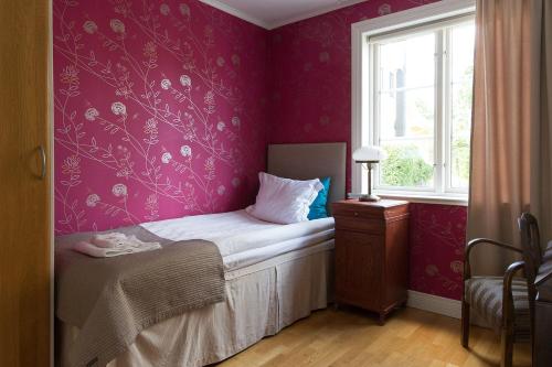 a small bedroom with a bed and a window at Hotell Villa Vesta in Ronneby