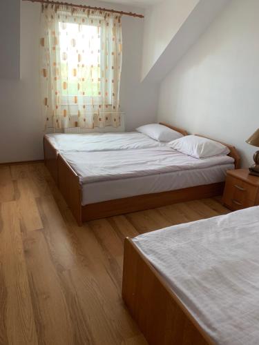 two twin beds in a room with a window at Agroturystyka Anita in Rutka Tartak