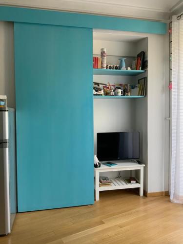 - une porte bleue dans le salon doté d'une télévision dans l'établissement Casa Dante, à Turin