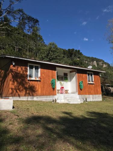 Casa pequeña con puerta blanca y ventanas en Cabana Pé Da Serra dos Bitus, en Urubici